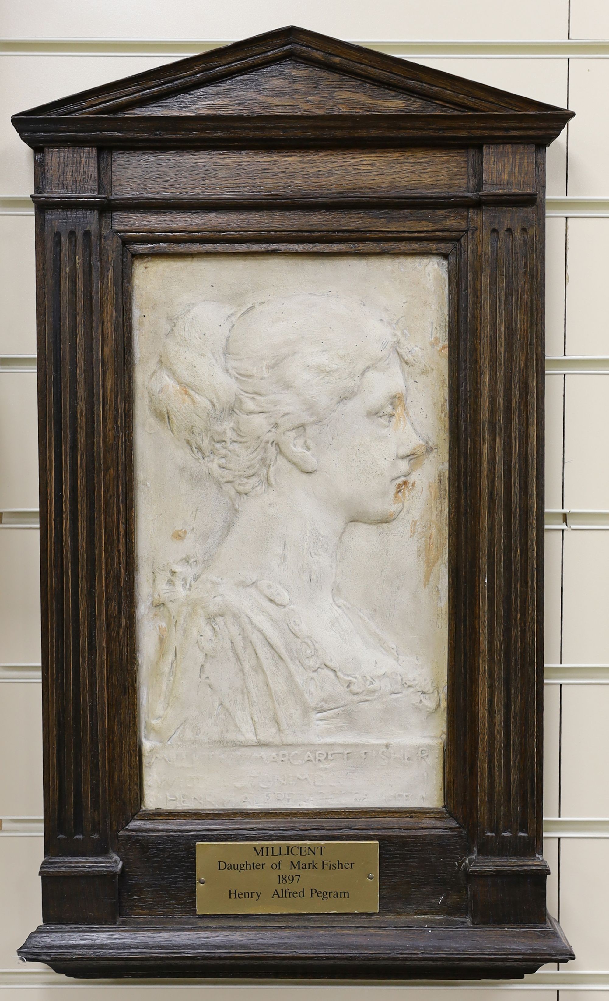 After Henry Alfred Pegram, ‘Millicent, Daughter of Mark Fisher’, a plaster relief panel in an architectural oak wall-hanging frame